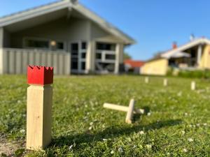 a wooden toy in the grass in front of a house at Nordseeperle-Ferienhaus in Otterndorf