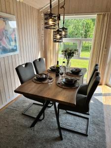 a dining room table with black chairs and a dining room at Nordseeperle-Ferienhaus in Otterndorf +18 photos