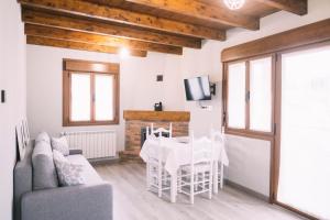 sala de estar con mesa de comedor y TV en Apartamentos El Valle, en Avín