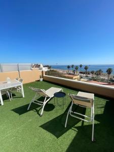 a group of chairs and tables on a balcony with the ocean at Coqueto estudio-ático EN PRIMERA LÍNEA DE PLAYA CON PRECIOSAS VISTAS AL MAR in Almería