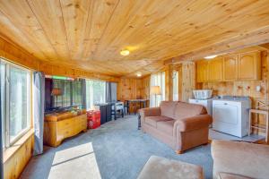 a living room with a couch and a chair in a tiny house at Beachfront Maine Retreat - Fire Pit, Grill and Canoe in Searsport
