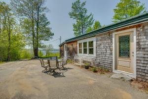a patio with two chairs and a house at Beachfront Maine Retreat - Fire Pit, Grill and Canoe in Searsport