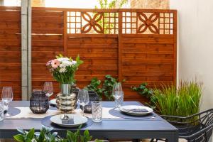 a table with plates and glasses and a vase of flowers at Suite für 4 mit Terrasse im Herzen der Innenstadt in Schwerin +16 photos
