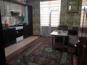 a living room with a table and a kitchen at Квартира для 5 человек в Нукусе in Nukus