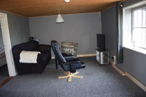 Uglev B&B في Thyholm: غرفة معيشة فيها كرسي وتلفزيون