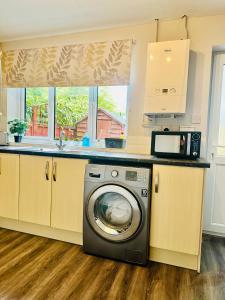 a kitchen with a washing machine in a kitchen at Townhouse in Derby in Derby