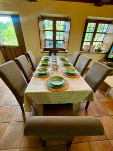 a dining room with a table with plates and wine glasses at La Bolera - Casa Pandal in Llanes +30 photos