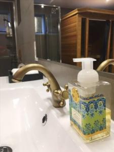 butelka mydła na zlewie w łazience w obiekcie Beautiful apartment with bathtub, sauna and gym w Ålesund