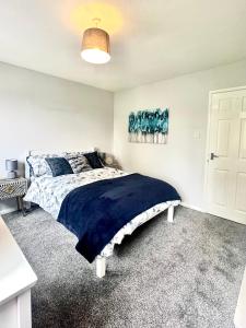 a bedroom with a large bed with a blue blanket at Townhouse in Derby in Derby