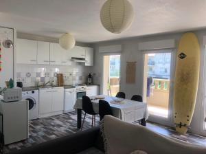 a kitchen and living room with a table and chairs at T2, bord de plage et piscine in Biscarrosse +5 photos