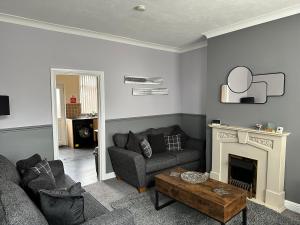 a living room with a couch and a fireplace at Cosy house in Wombwell in Barnsley