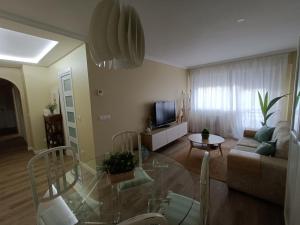 uma sala de estar com uma mesa de vidro e um sofá em Apartamento Doctor Tourón em Vilagarcía de Arousa
