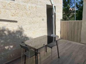 a table and two chairs sitting on a patio at בית נופש בוטיק - Boutique holiday home in Bayit Wegan