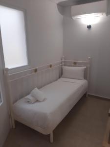 a white bed in a room with a window at Lavender Green Villas in Agios Nikitas