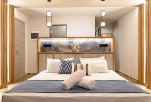 um quarto com uma grande cama branca com almofadas em Mythic Summer Hotel em Paralia Katerinis