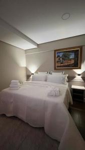 a bedroom with a large white bed with towels on it at Hotel Dan Inn Uberlandia in Uberlândia