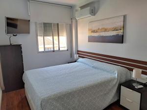 1 dormitorio con cama, ventana y TV en Apartamento con encanto y vistas al mar, en Torre de Benagalbón