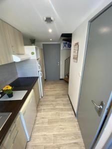 eine kleine Küche mit einem Kühlschrank und einem Flur in der Unterkunft VUE MER POUR 4 PERSONNES in Guidel
