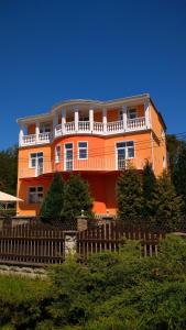 an orange building with a fence in front of it at Pension Fami Retro Design in Staré Splavy