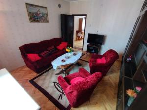 a living room with two red chairs and a table at Libero house in Smederevo