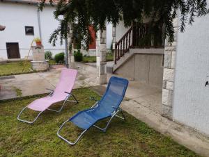 two chairs sitting in the grass next to a house at Libero house in Smederevo