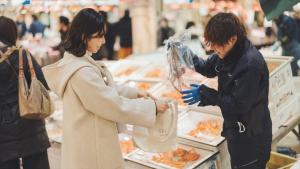 a man and woman preparing food in a grocery store at SOKI KANAZAWA - Vacation STAY 40338v in Kanazawa