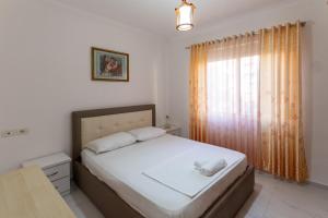 Habitación pequeña con cama y ventana en Comfortable apartment next to the beach, en Durrës