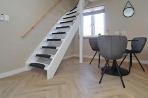 a staircase in a living room with a table and chairs at appartement-gratis parkeren -bij strand en in het centrum in Noordwijk