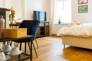 a bedroom with a bed and a desk and a table at Suite für 4 mit Terrasse im Herzen der Innenstadt in Schwerin