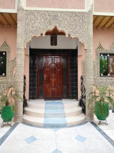 einen Eingang zu einem Haus mit einer Holztür in der Unterkunft Villa Eden in Ouarzazate