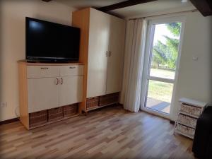 a living room with a flat screen tv and a sliding door at Domki letniskowe in Mikołajki