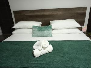 ein Bett mit einem Stapel gefalteter Handtücher drauf in der Unterkunft Olive Exclusive in Gaborone