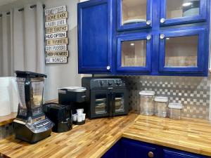 Eine Küche mit blauen Schränken und einem Mixer auf einer Holzarbeitsplatte. in der Unterkunft Charming Farmhouse Retreat near Downtown & University Modern Amenities, Fireplace & Porch! in Birmingham + 27 Fotos