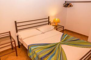 um quarto com uma cama e um candeeiro sobre uma mesa em Nº87 Confortável T2 Porto antigo em Santa Maria