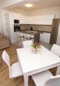 a kitchen and living room with a white table and chairs at Ohrid City Apartments in Ohrid