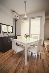 a dining room with a white table and chairs at Ohrid City Apartments in Ohrid +1 photo