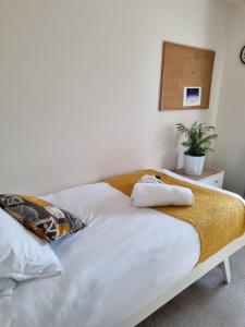 Una cama blanca con toallas en un dormitorio en Deluxe room in a spacious house en Kirby Muxloe