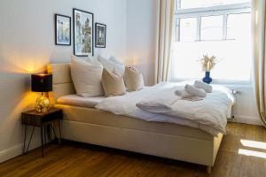 a bedroom with a bed with white pillows and a window at Suite für 4 mit Terrasse im Herzen der Innenstadt in Schwerin