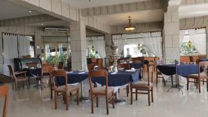 un comedor con mesas y sillas azules en Hotel Hacienda las Higueras, en Tepic