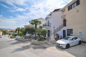 ein weißes Auto, das vor einem Gebäude parkt in der Unterkunft Guesthouse Kate in Trogir