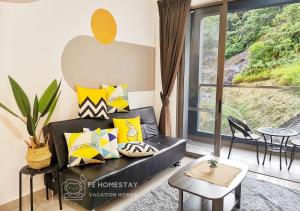 ein Wohnzimmer mit einem schwarzen Sofa und gelben Kissen in der Unterkunft FE Cozy Cameron Homestay Family 8 pax 3BR Palas Horizon Brinchang 金马伦民宿 8人3房 in Brinchang