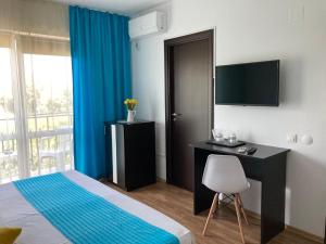 a bedroom with a bed and a desk and a television at Vila Sofia in Eforie Nord