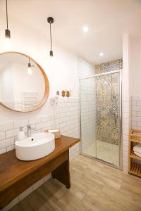 a white bathroom with a sink and a shower at Willa Pod Lasem in Tupadły