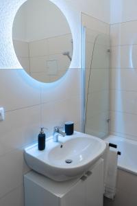 a white bathroom with a sink and a mirror at Suite für 4 mit Terrasse im Herzen der Innenstadt in Schwerin