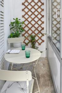 シャルトルにあるLes Toits de Chartres - 2 appt - Parking gratuitの窓付きの客室で、白いテーブルと椅子が備わります。