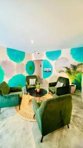 a living room with green furniture and a wall with blue at URB Hotel in Fortaleza