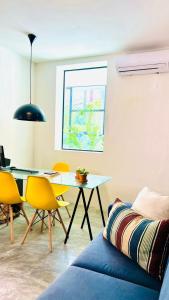 a living room with a table and yellow chairs at URB Hotel in Fortaleza