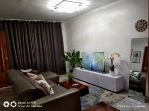 uma sala de estar com um sofá e uma televisão em MARLS PLACE FULLY FURNISHED, 4 mins walk to SM MALL and GAISANO MALL FB name Marls Place em Butuan