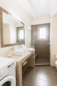 a bathroom with a sink and a washing machine at Stone Pearl Kea in Elliniká