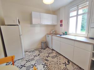 kuchnia z białymi szafkami i białą lodówką w obiekcie T2 cosy centre ville w mieście Luchon +5 zdjęć